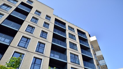 Exterior of new apartment buildings on a blue cloudy sky background. No people. Real estate business concept.