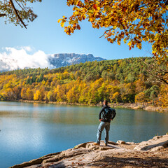 Person am Montiggler See in Südtirol im Herbst