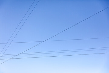 Electric wires against the blue sky. Background