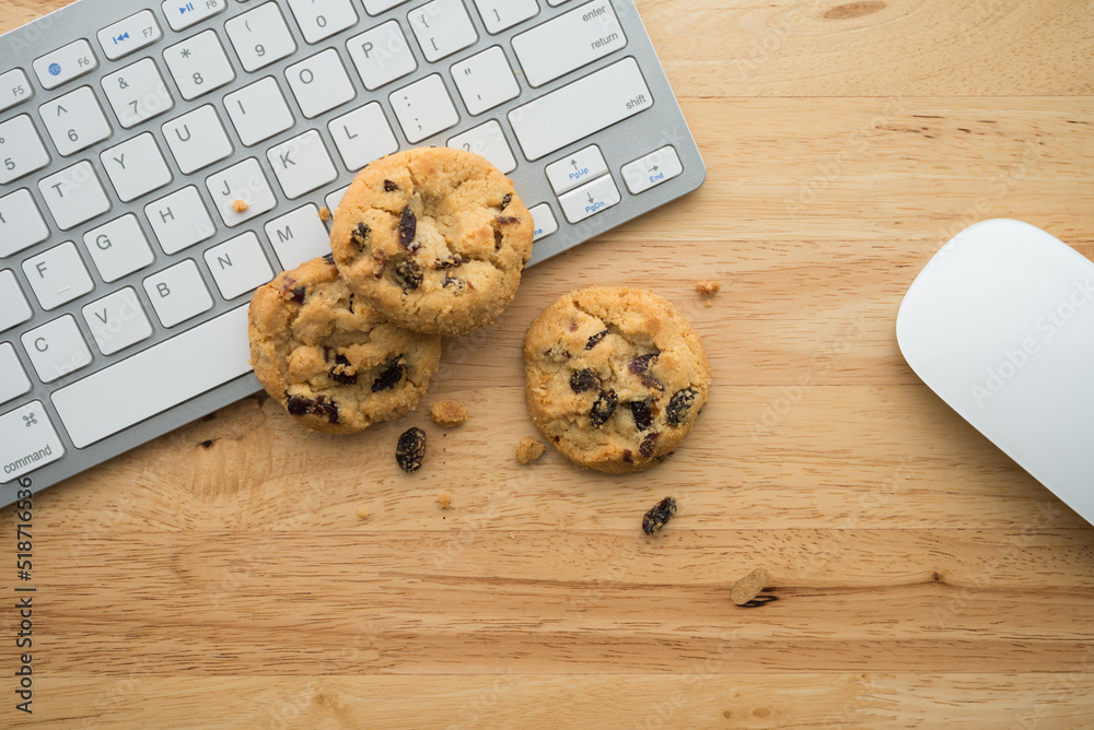 Wall mural flat lay of white chocolate chip cookies on keyboard computer and mouse on wooden table background c