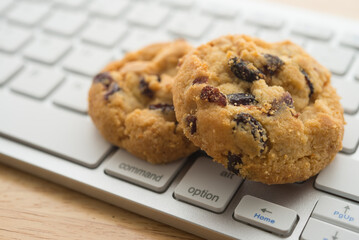 White chocolate chip cookies on keyboard computer background copy space. Cookies website internet...
