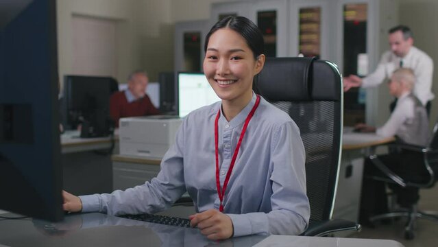 Enthusiastic asian it programmer working on desktop computer. 