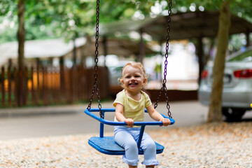 Blurred happy girl in motion swinging on a swing