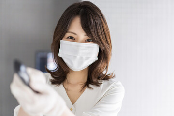 感染拡大防止のためにお客様の体温を計測するスタッフ