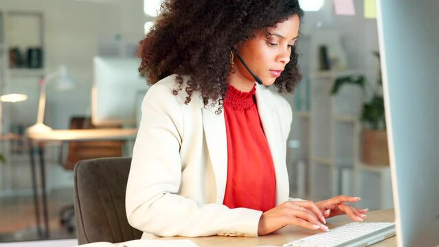 Young call center agent typing on a computer while consulting for customer service and sales support. Focused business woman wearing a headset and logging online inquiries while operating a helpdesk
