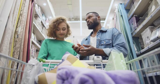 Low Angle View Of Sad Multiethnic Couple Count Money In House Improvement Store. Realtime