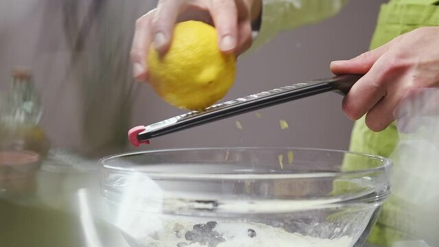 Chef grates lemon zest with a grater.
