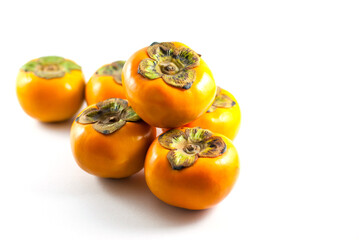 Six persimmons on a white background.