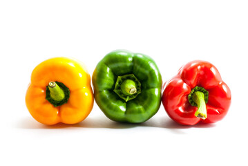 Three colors of bell peppers, yellow, green, red isolated on a white background.