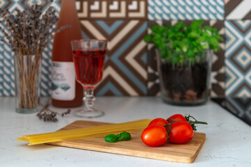 tomatoes, basil and pasta on a wooden board