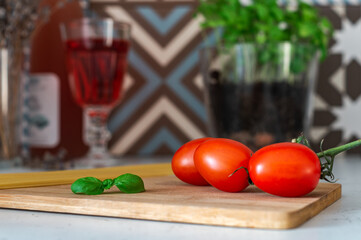 tomatoes, basil and pasta on a wooden board