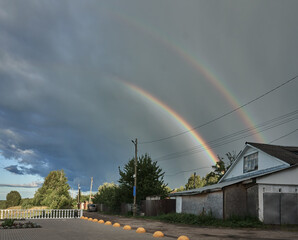 Rain clouds in which a real rainbow has formed, I am in nature. Double rainbow, cumulus clouds, heavy rain, selective focus