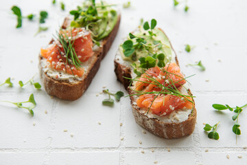 Sandwiches with salted salmon,  avocado and microgreens.