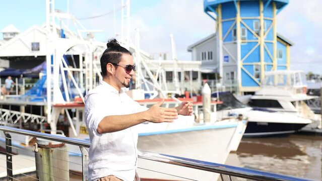 海に向かって大きく手を振るヒスパニック系男性
