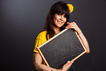 Latin brazil lady in a soccer clothes holding a empty blackboard on his native language isolated on...