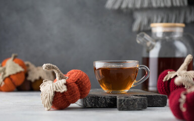  Mug with black tea with knitted decorative pumpkins. The concept of autumn and coziness. Autumn tea.