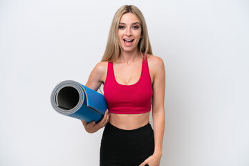 Young sport blonde woman going to yoga classes while holding a mat isolated on white background with surprise facial expression