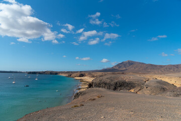 Fototapeta na wymiar Vista aérea de la playa de la cera, en Lanzarote. Islas Canarias. cielo azul sobre una cala en verano. paisaje árido y volcán de fondo. 