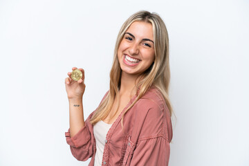 Obraz premium Young caucasian woman holding a Bitcoin isolated on white background smiling a lot