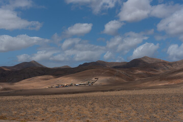 Impresionante paisaje volcánico y desértico con un pueblito de casas blancas y al fondo pequeñas...