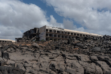 Vista panorámica de un edificio en ruinas y abandonado en un paisaje rocoso durante un día nublado en la costa de Lanzarote en Islas Canarias