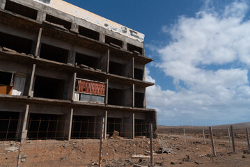 Vista panorámica de un edificio en ruinas y abandonado con un cartel de se vende en un paisaje...