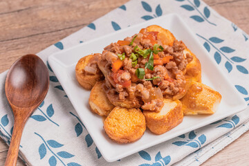 Fried tofu stir fried with ground pork and vegetables in white plate