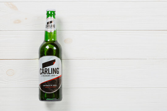 A bottle of Carling beer on a wooden background with copy space	