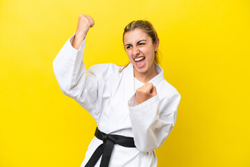 Young caucasian woman doing karate isolated on yellow background celebrating a victory © luismolinero