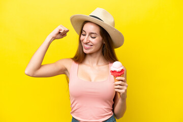 Young caucasian with a cornet ice cream isolated on yellow background celebrating a victory