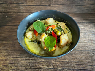 Thai food Green curry chicken on wooden background.