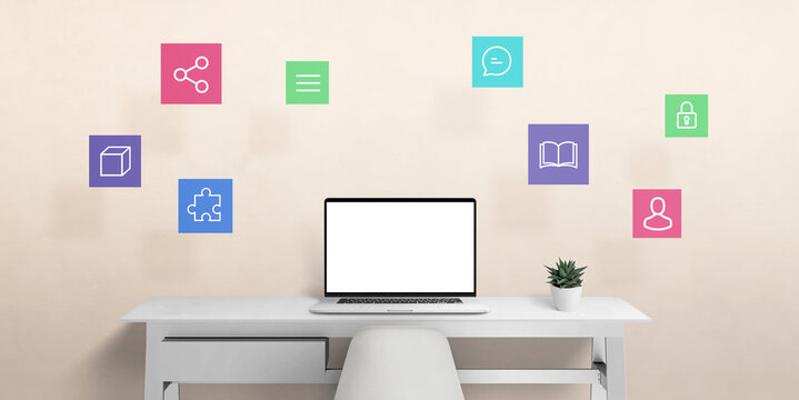 Laptop computer on work desk with internet of things icons in air. Isolated screen for mockup, web page presentaiton