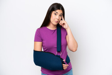 Young Brazilian woman with broken arm and wearing a sling isolated on white background thinking an idea