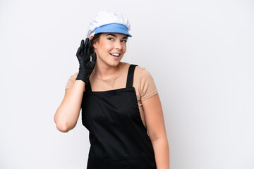 Fishmonger brazilian woman wearing an apron isolated on white background listening to something by putting hand on the ear