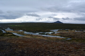 Lava field in Iceland Godafoss Falls area on the background of distant mountains and stormy sky