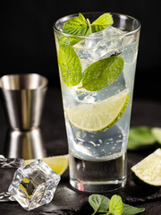One glass of mojito cocktail with mint, lime and ice cubes