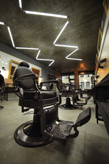 stylish modern empty barbershop interior with chairs, mirrors and lamps. Barbershop armchair,...