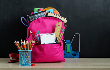 Pink school backpack and stationery on a black background. - obrazy, fototapety, plakaty