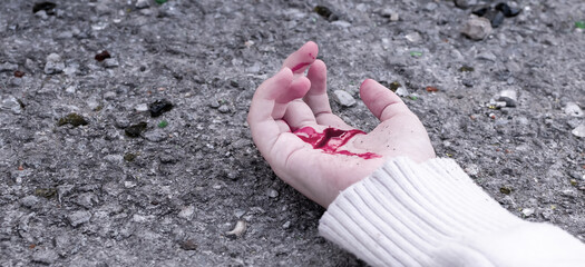 a man's hand is covered in blood lying on the asphalt on the road
