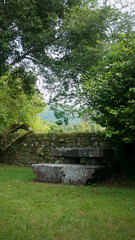 Banco y mesa de piedra junto a muro de piedras en jardín