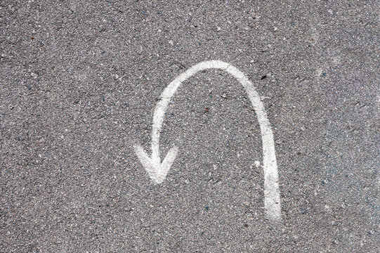 Turning sign on road. Turn back asphalt road texture background.