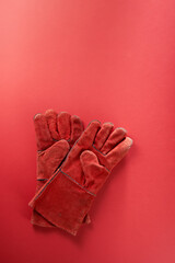 Pair of work gloves isolated on red  background, close up