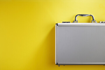 stainless steel brief case against yellow background