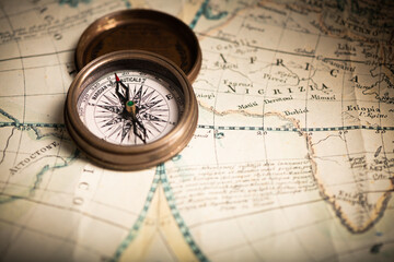 Antique compass lying on old style map