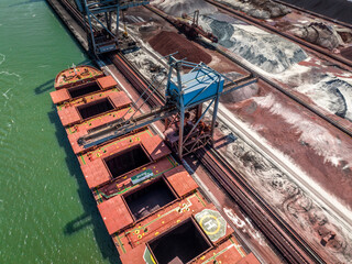 Fototapeta na wymiar Cranes Unloading Cargo from a Bulk Carrier Ship at Port