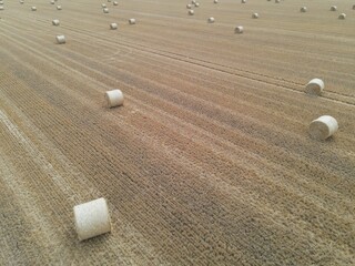 Drone high view of sunny day UK field with hay bales