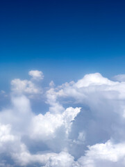 High up fluffy clouds. Beautiful sky view from airplane window. Air travel background with copy space. Looking out aircraft bull's eye. Beautiful scenery from the air through plane porthole. 