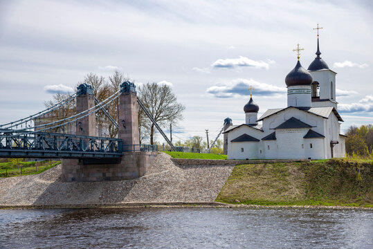 View of the chain bridge and the Church of St. Nicholas the Wonderworker, the city of Ostrov. Pskov region, Russia