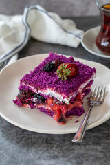 Fruit cake slice. Forest fruit cake on a dark background. Bakery products. Vertical view. Close-up.