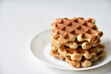 Viennese waffles on a white plate. Delicious waffles for breakfast.